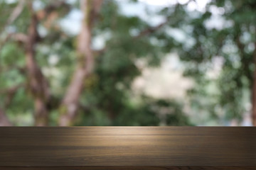 Image of wooden table in front of abstract blurred background of outdoor garden lights. can be used for display or montage your products.Mock up for display of product.