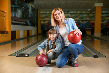 Woman with little daughter in bowling club