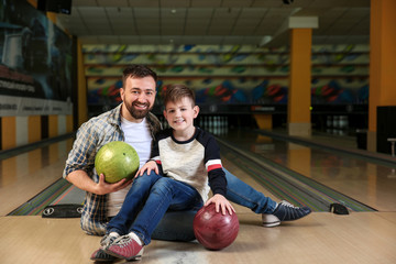 Fototapeta premium Man with his little son in bowling club
