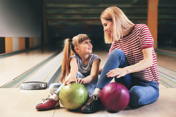 Fototapeta premium Woman and her little daughter in bowling club