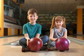 Fototapeta premium Little children with balls in bowling club