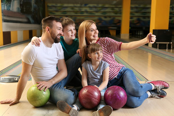 Fototapeta premium Family taking selfie in bowling club