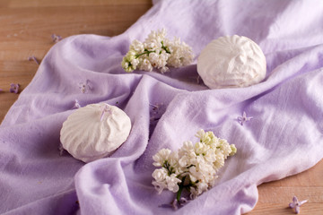 white marshmallow and flowers on purple fabric on the table