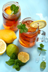 Iced tea with lemons, limes and mint with ice cubes, summer refreshment drink