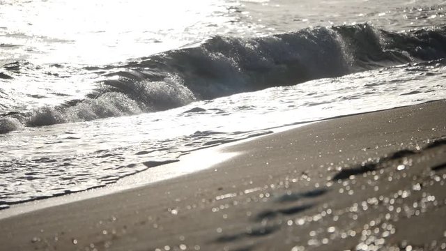 im V-Log-Modus gedreht als Slowmotion, wie die Wellen sich an den Strand werfen und sich langsam wieder zurueckziehen