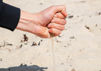 sand pours from the hand of man