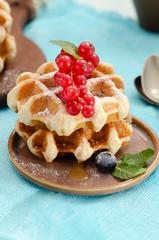 Breakfast with belgian waffles with honey caramel sauce and summer berries