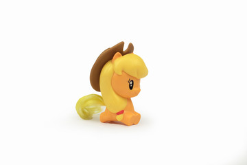 Toy yellow pony in in the slap with a yellow mane on a white background