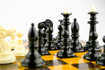 white chess pieces stand on a chessboard during a game of chess, focus in the center of the board