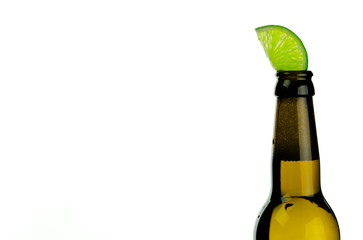 isolated brown beer bottle with a slice of green lime on a white background and copy space