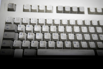 A close view of some keys on a dirty, yellowed keyboard. close up enter button