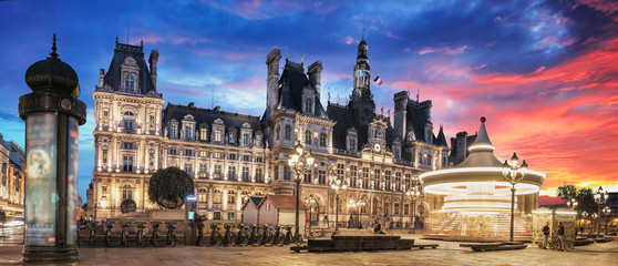 Paris City Hall (Hotel de Ville) at sunset with spinning carousel in the front square. Paris,...