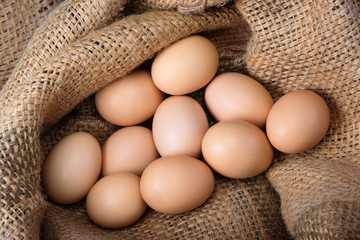 Eggs from a farm on burlap close up. Top view, healthy food, natural protein.