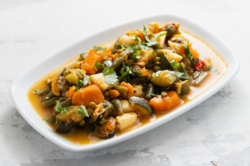 seafood with vegetables and herbs on white dish