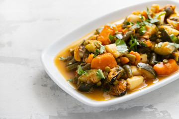 seafood with vegetables and herbs on white dish