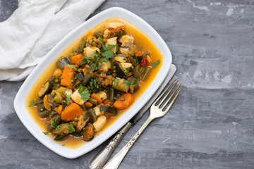 seafood with vegetables and herbs on white dish