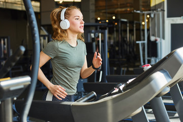 Pretty woman jogging in gym