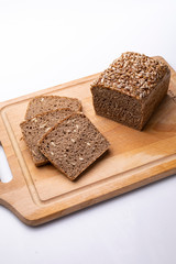 Bread with grains. Traditional rye bread on a wooden board on a white background.