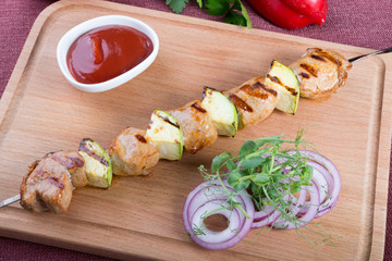 Grilled meat with zucchini on a metal skewer