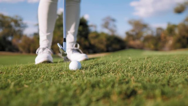 Golfer prepare herself to take a shot ball close-up
