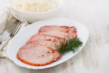 fried pork with herbs on white dish on wooden background