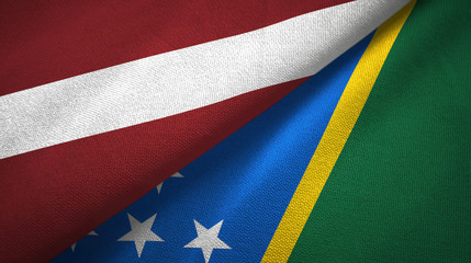 Fototapeta premium Latvia and Solomon Islands two flags textile cloth, fabric texture