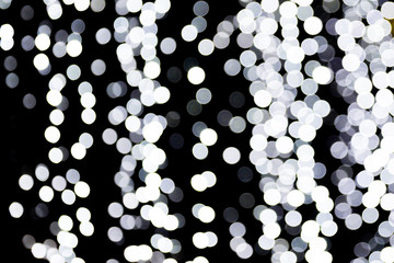 Bokeh white lights on black background. Abstract defocused many round light