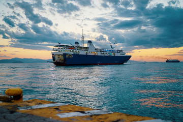 Fototapeta premium Travel by Greece. Beautiful sunset landscape with big ferry and sea wharf.