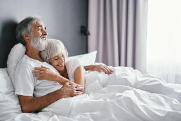Happiness and tender. Senior family. Husbang hugging his wife in bed.