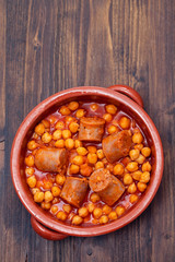 spanish sausage with chick-pea in small brown ceramic dish