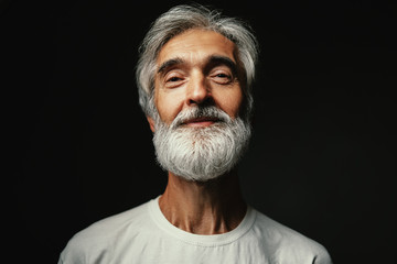 Studio portrait of handsome senior man with gray beard.
