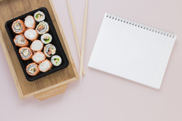 Flat lay sushi composition with notepad template