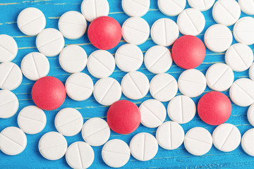 Bright blue wooden background with spillt white tablets