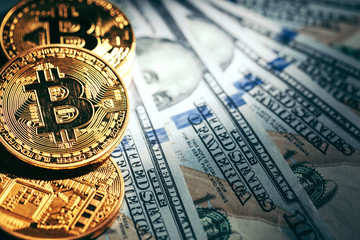 Golden bitcoin coins on a paper dollars money