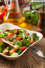 Delicious salad with grilled veal, beetroot and cucumber. Front view.