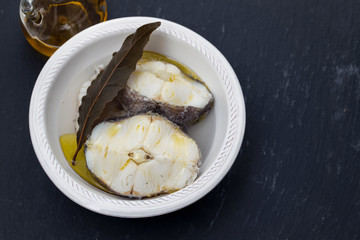 boiled fish with olive oil in white bowl