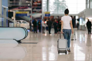 traveler young woman walking with suitcase in an airport