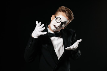 portrait of mime man in tuxedo and glasses on black background