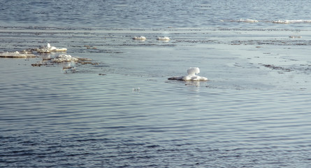 Snow pile, hill. Large snow drift isolated on a blue sky background,  outdoor view of ice blocks at frozen finland lake in winter