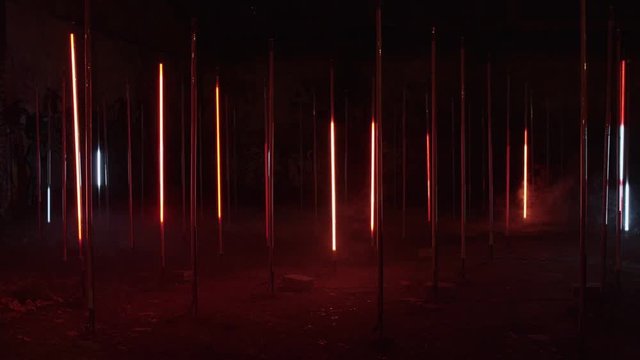 Strange and creepy, colorful beaming lights glow in night darkness. Sci-fi atmosphere of extraterrestrial or spaceship aircraft. Futuristic art installation