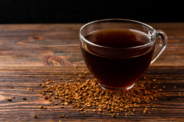 Granulated coffee on dark wooden background.