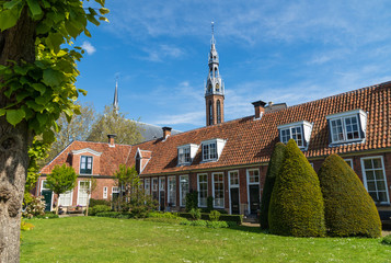Old almshouses around a small, green courtyard (Sint Anthony Gasthuis) in the Dutch city of...