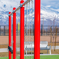 Clear Square Swings on a playground with snow covered mountain in the background