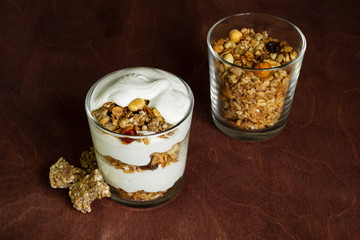 Healthy breakfast with granola and homemade yogurt in a glass. Rustic style	