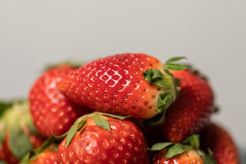 selective focus of red sweet and organic strawberries on grey