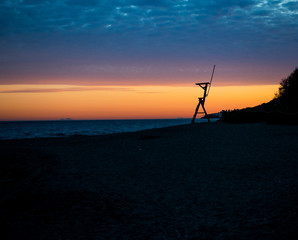 Fototapeta na wymiar Sunset on a Mediterranean beach, next to a coastal surveillance post