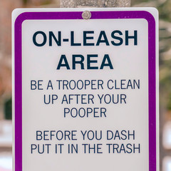 Clear Square On Leash Area sign on a snow covered park on a sunny winter day