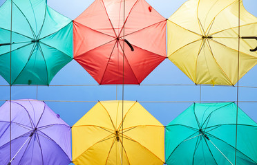 The image of colorful umbrellas on a background of blue sky