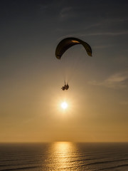 Paragliding on the cliffs of the city of Lima during sunset