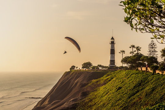Paragliding on the cliffs of the city of Lima during sunset